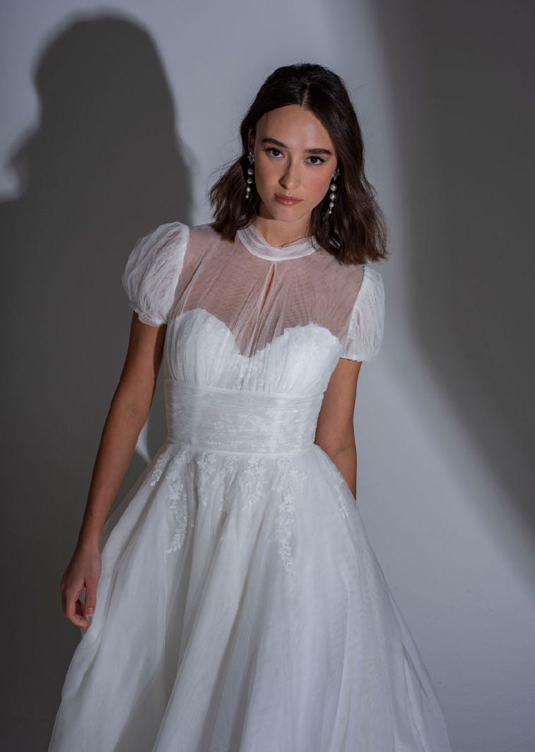 The bodice of the Adelaide contemporary lace and tulle wedding dress with high neck and small puff sleeves.