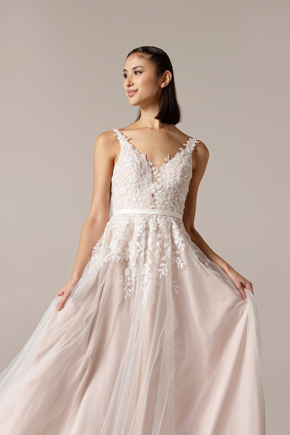 Closeup of the Lyra tulle and lace, V neckline soft silhouette Boho bridal or ball gown with pretty lace over bodice that trails into the skirt.
