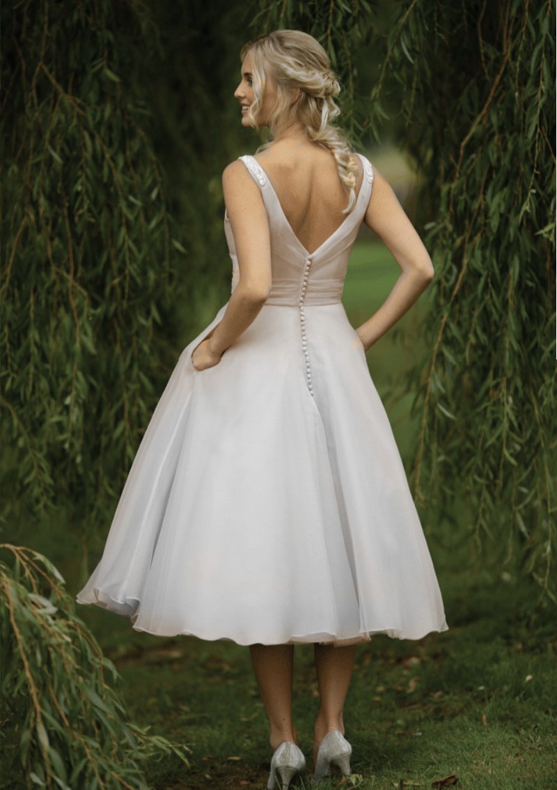 Back of vintage inspired  short 40's style wedding gown with fine appliqués to the shoulders, pleated fitted bodice and full Fifties organza skirt