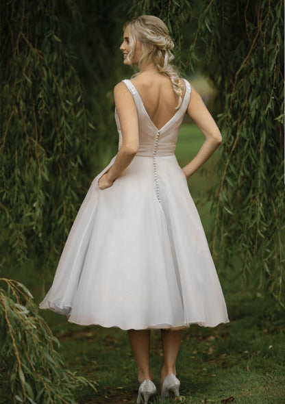 Back of vintage inspired  short 40's style wedding gown with fine appliqués to the shoulders, pleated fitted bodice and full Fifties organza skirt